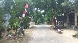 Persiapan Penutupan TMMD Reguler ke-128, Sertu Nursanto Pasang Umbul-Umbul di Lokasi Kegiatan