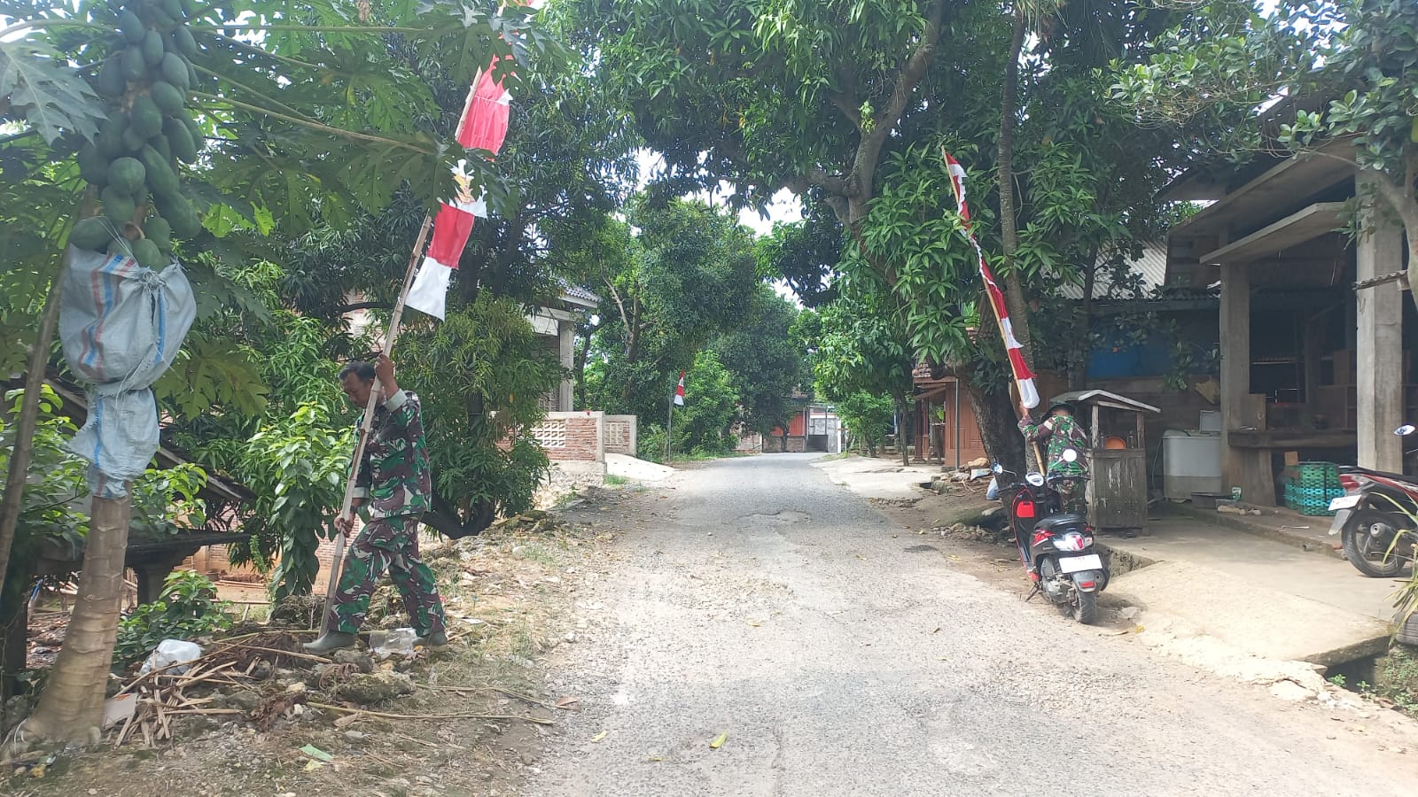 Persiapan Penutupan TMMD Reguler ke-128, Sertu Nursanto Pasang Umbul-Umbul di Lokasi Kegiatan