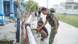 Satgas TMMD Bersama Warga Gotong Royong Cat Pagar di Desa Umbele