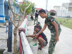 Satgas TMMD Bersama Warga Gotong Royong Cat Pagar di Desa Umbele