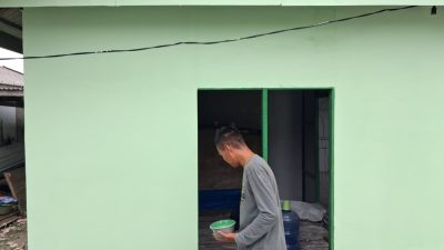 Satgas TMMD Ke-129 Lanjutkan Pengecatan Dinding Luar RTLH Milik Bapak Suhardin